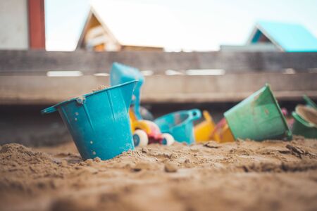 Children plastic toys in the sand box. Dirt bucket, selective focus. の写真素材