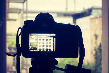 Professional with telephoto lens on tripod, surveillance and stalking