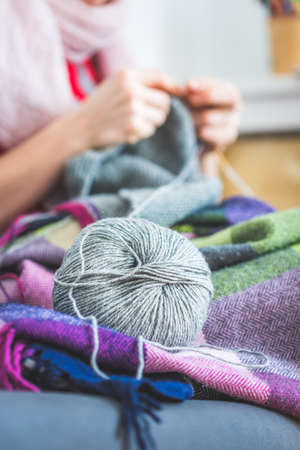 Close up of female fingers knitting at home