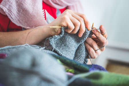 Close up of female fingers knitting at homeの写真素材