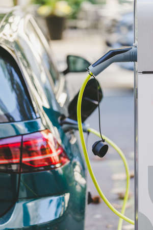 Electric car recharging with charge cable and plug leading to charge pointの写真素材