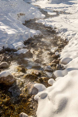 Idyllic winter landscape: stunning mountain range, beautiful river, snowy trees and blue skyの写真素材