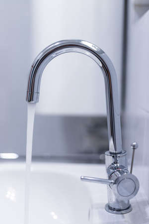 Close up of a water spigot in a clean bathroom. Water saving.