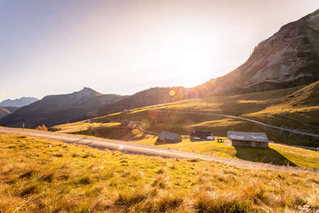 Beautiful scenic mountain scenery with huts and warm colors, sundownの写真素材