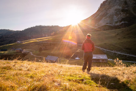 Woman in sportswear is enjoying the sunset in the mountains: sitting on the ground and enjoying the view. Alpes, Austriaの写真素材