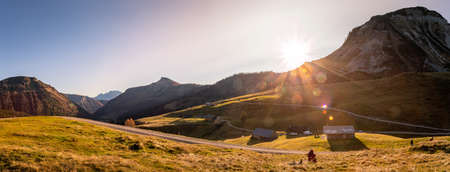 Beautiful scenic mountain scenery with huts and warm colors, sundownの写真素材