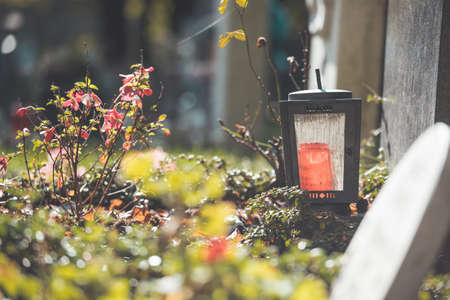 Candle in an iron lantern on a grave at a cemeteryの写真素材