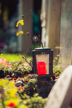 Candle in an iron lantern on a grave at a cemeteryの写真素材