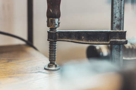 Close up of a metal screw clamp in a garage workshop