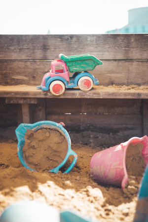 Children plastic toys in the sand box. Dirt bucket, selective focus.の写真素材
