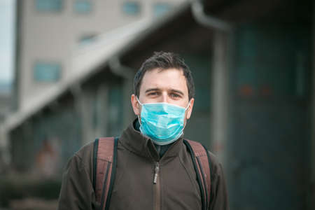 Young man outdoors wearing a face mask. Corona and flu season.の写真素材