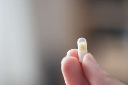 Male hand holding drug or vitamin pill inの写真素材