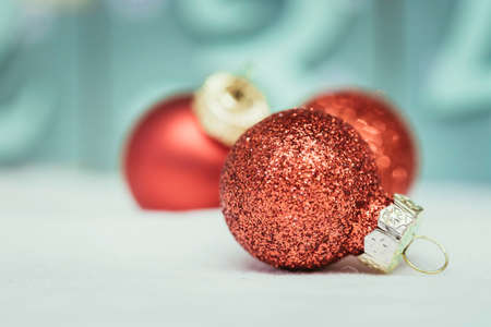 Christmas decoration: Close up of red Christmas baubles, advent calendar in the blurry background