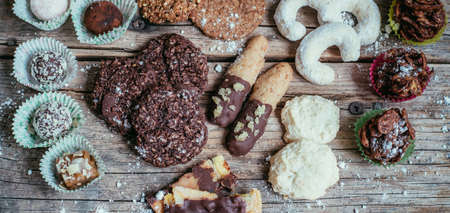 Closeup of variety of traditional European homemade Christmas cookies on rustic wooden desk