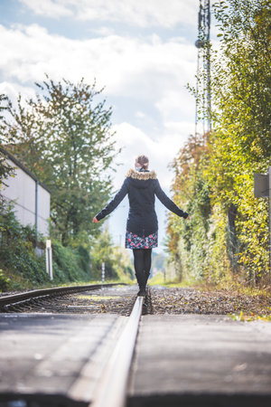 Girl waking on abandoned railroad, autumnの写真素材