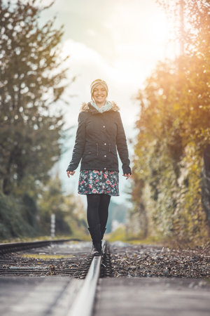 Girl waking on abandoned railroad, autumnの写真素材