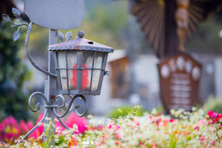 Candle in an iron lantern on a grave at a cemeteryの写真素材