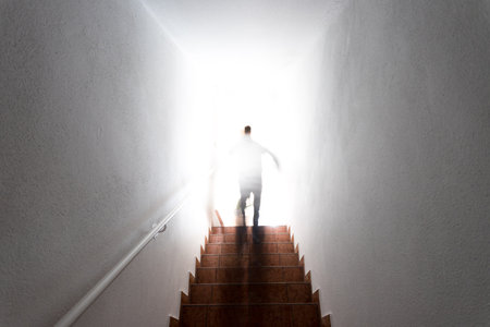 Man is going up on basement stairs with balustrade. Natural bright sunlight.の写真素材