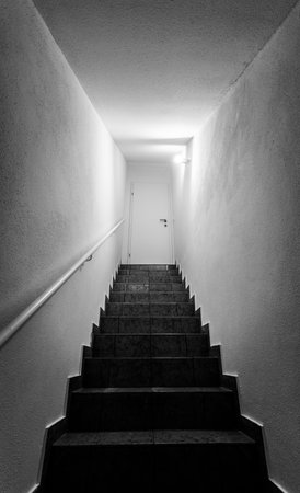 Basement stairs with balustrade, closed white doorの写真素材