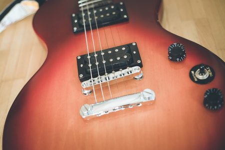 Electronic guitar in sunburst optic lying on the wooden floorの写真素材