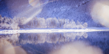 Idyllic winter landscape: Reflection lake, snowy trees and mountainsの写真素材