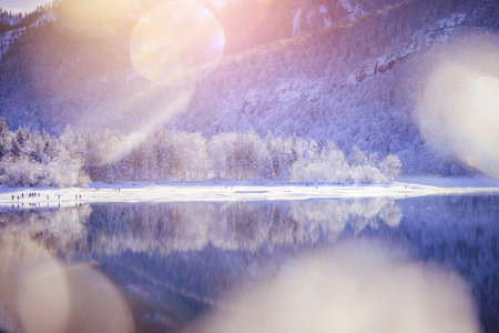 Idyllic winter landscape: Reflection lake, snowy trees and mountainsの写真素材