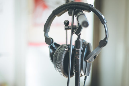 Professional audio headphones with cables on a stand, blurry backgroundの写真素材