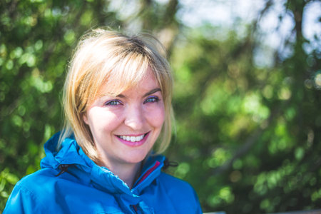 Portrait of attractive young girl outdoors, spring time, blurry green backgroundの写真素材
