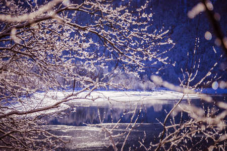Idyllic winter landscape: Reflection lake, snowy trees and mountainsの写真素材
