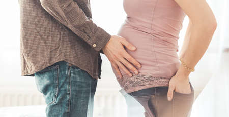 Close up of pregnant mother and father, hugging the tummy, Caucasianの写真素材