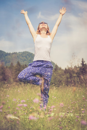 Young girl is doing yoga in the parkの写真素材