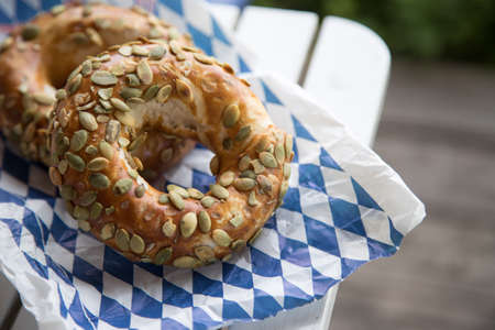Fresh Bavarian Pretzels for breakfast, lying on a wooden table outdoors
