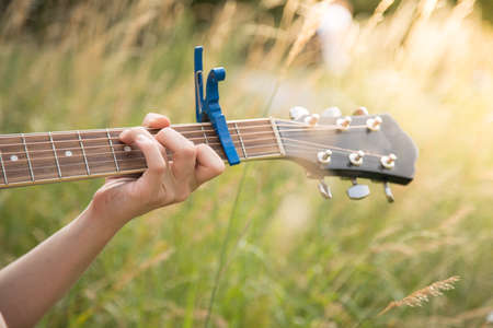 Close up of western guitar played outdoors at a river, summertimeの写真素材