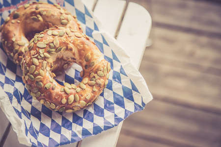 Fresh Bavarian Pretzels for breakfast, lying on a wooden table outdoorsの写真素材