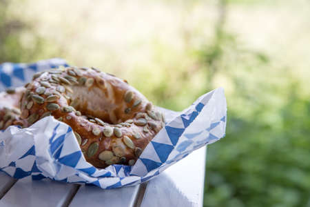 Fresh Bavarian Pretzels for breakfast, lying on a wooden table outdoorsの写真素材