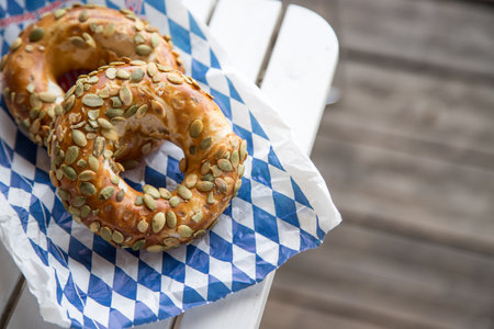 Fresh Bavarian Pretzels for breakfast, lying on a wooden table outdoorsの写真素材