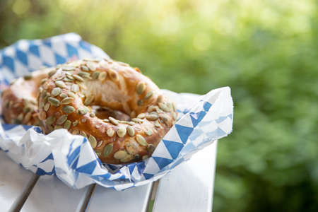 Fresh Bavarian Pretzels for breakfast, lying on a wooden table outdoorsの写真素材