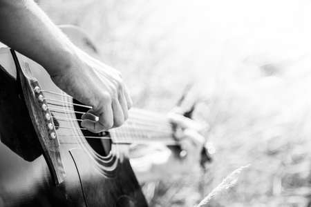 Close up of western guitar played outdoors at a river, summertimeの写真素材