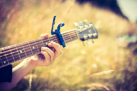 Close up of western guitar played outdoors at a river, summertimeの写真素材