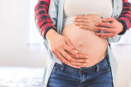 Close up of pregnant mother and father, hugging the tummy, Caucasianの写真素材