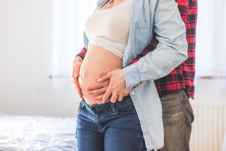 Close up of pregnant mother and father, hugging the tummy, Caucasianの写真素材