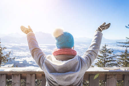 Back of young woman who is raising her hands on the mountain, outlook. Gaisberg, Austriaの写真素材