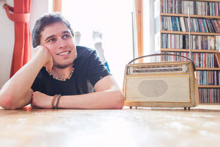 Young man listing to an retro radioの写真素材
