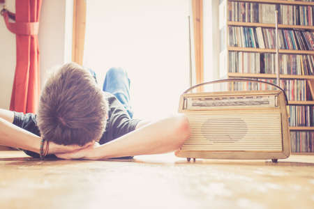 Young man listing to an retro radioの写真素材