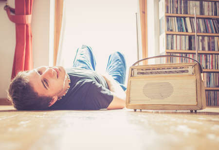 Young man listing to an retro radioの写真素材