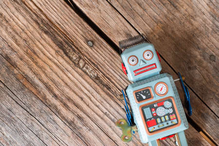 Robot toy, symbol for a chatbot or social bot and algorithms. Wood texture.の写真素材