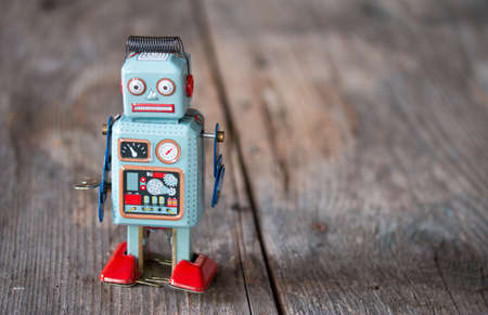 Robot toy, symbol for a chatbot or social bot and algorithms. Wood texture.の写真素材