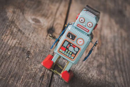 Robot toy, symbol for a chatbot or social bot and algorithms. Wood texture.の写真素材