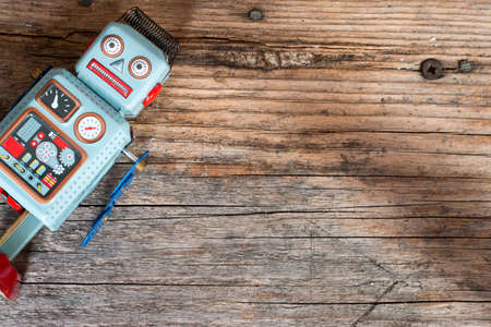 Robot toy, symbol for a chatbot or social bot and algorithms. Wood texture.の写真素材