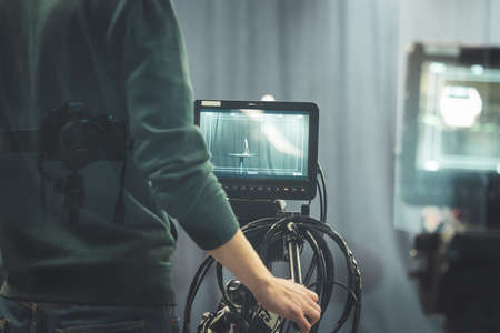 Male cameraman is operating a film camera in a television recording studio